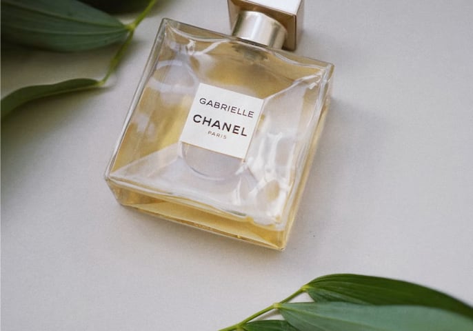 a bottle of perfume surrounded by leaves